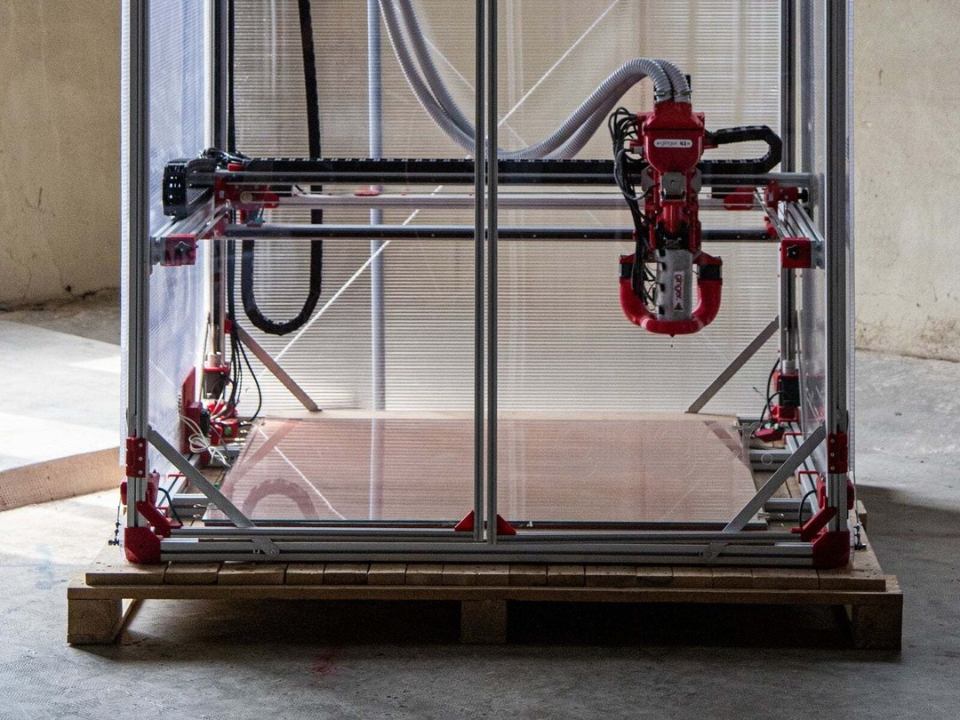 Impressora 3D de pellet Ginger G1 sobre palete de madeira em galpão industrial