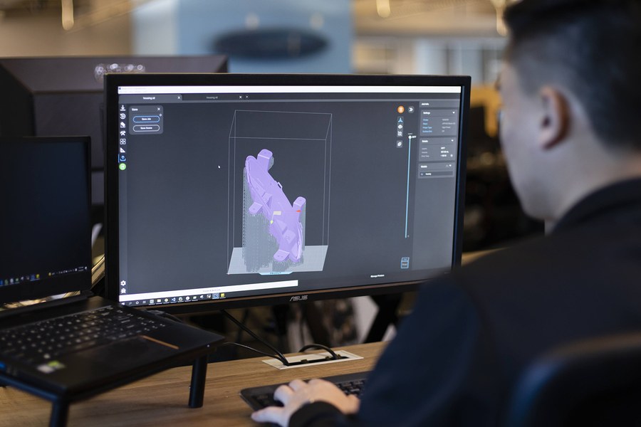 Profissional da Voxel em estação de trabalho, analisando um modelo tridimensional na tela