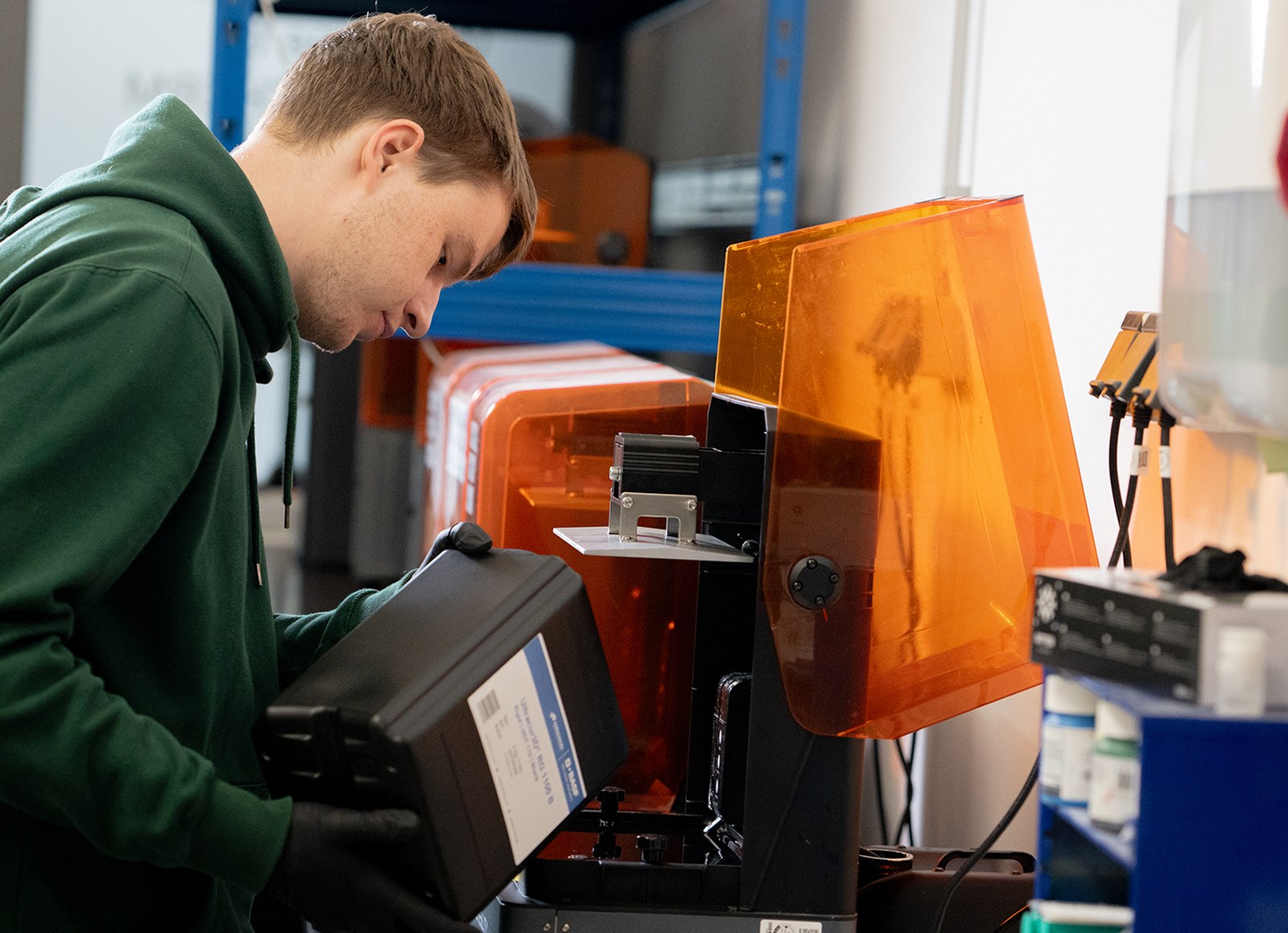 Técnico da Voxel operando uma impressora 3D industrial