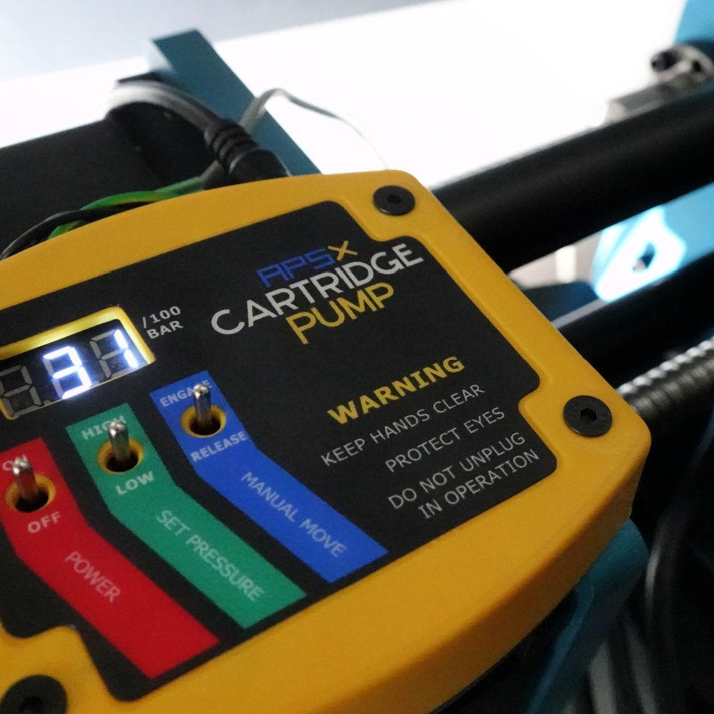 Painel amarelo da bomba de cartucho da APSX-LSR, com o visor de pressão e as chaves de comando