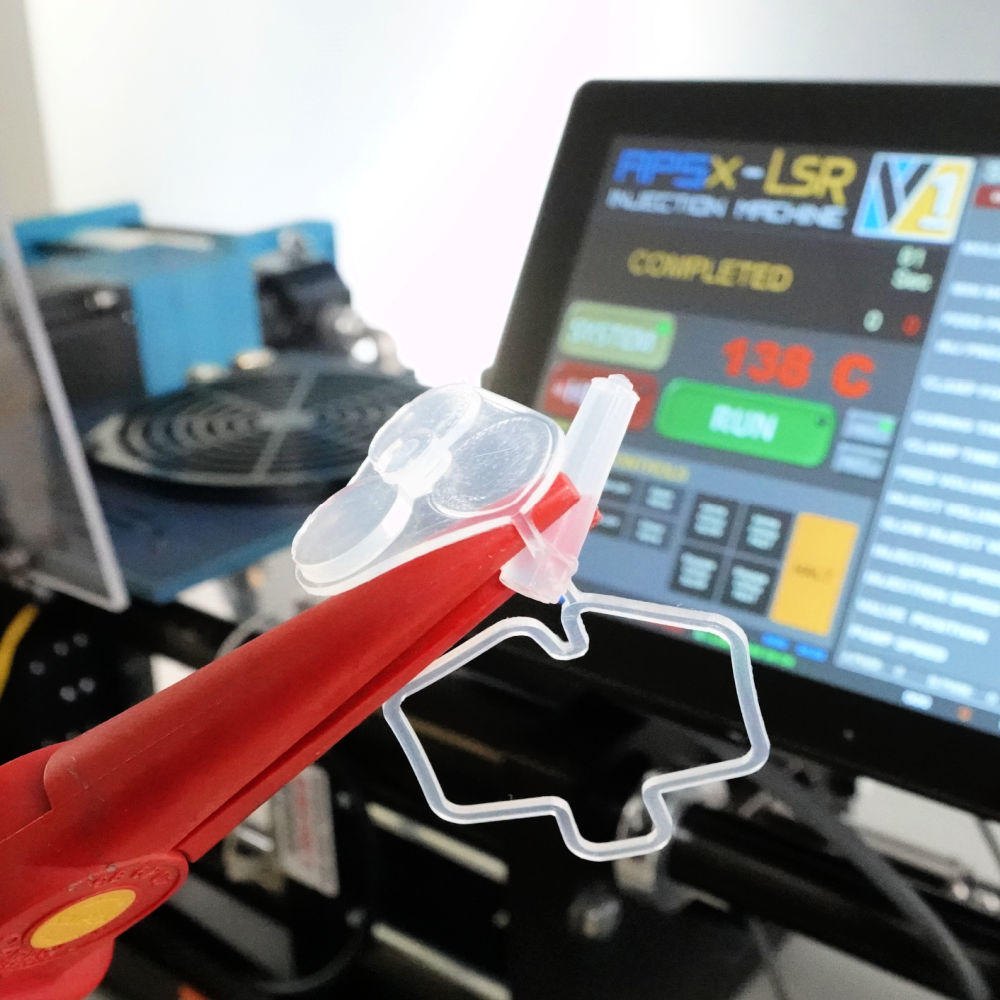 Peças de silicone vermelha e transparente diante da tela de comando da APSX-LSR