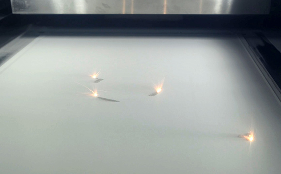 Lasers fundindo pó metálico na câmara de construção da Farsoon FS621M