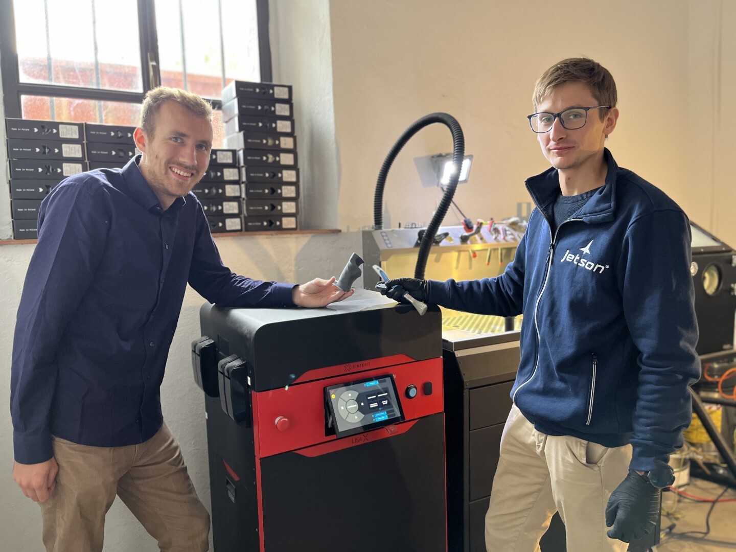 Engenheiros da Jetson ao lado da impressora 3D SLS Sinterit Lisa X no laboratório de desenvolvimento